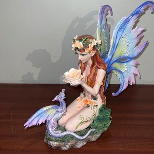 Fairy statue holding a rose with dragon at knees
